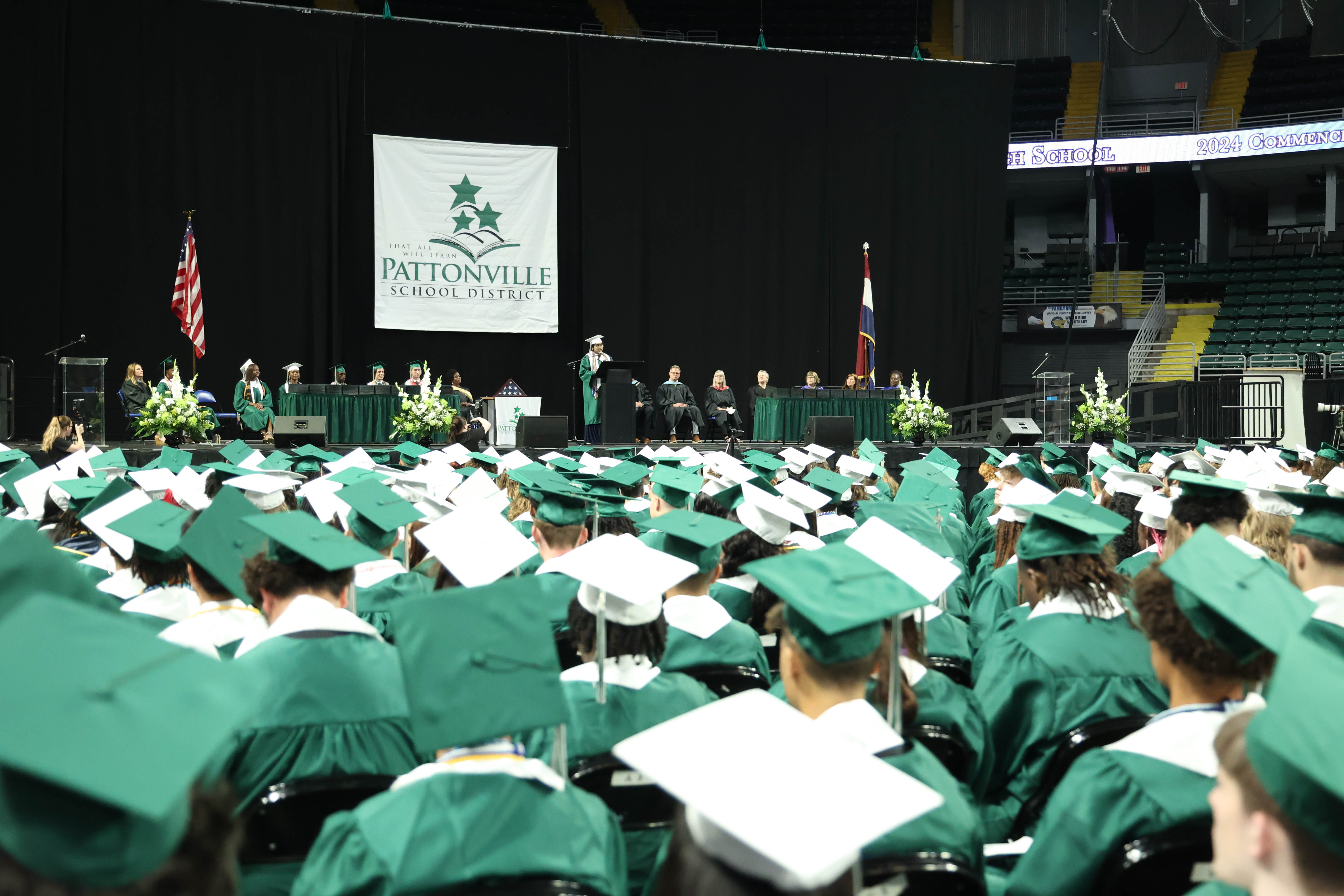 Students attend a graduation ceremony and listen to a speaker